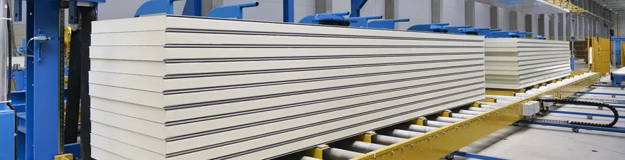 Sandwichplatten werden als Dach- & Wandverkleidung immer beliebter und bieten sehr gute Dämmeigenschaften Gestapelte Sandwichplatten im Werk, kurz vor der Verpackung und Verladung.