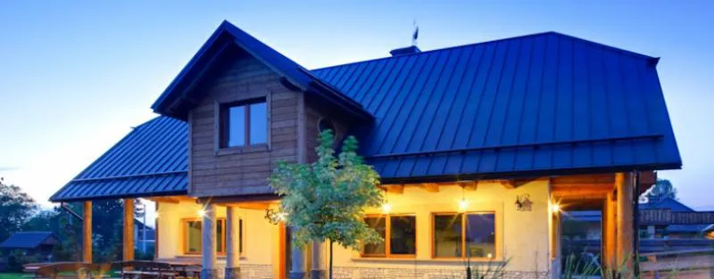 Wohnhaus in der Abenddämmerung mit einer Stehfalz-Dacheindeckung FixClick 5 T Wohnhaus in der Abenddämmerung mit einer Stehfalz-Dacheindeckung FixClick 5 T